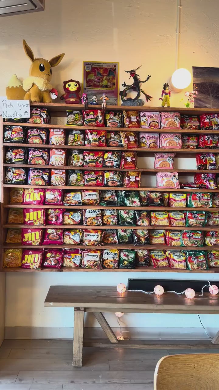 Busy self-serve ramen restaurant in Albuquerque with a noodle wall and full tables