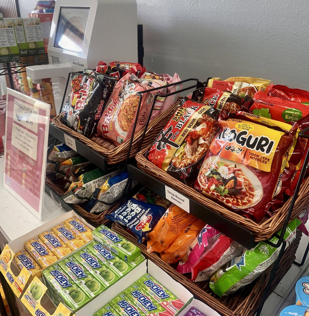 Baskets of Korean noodle packs next to the ramen station