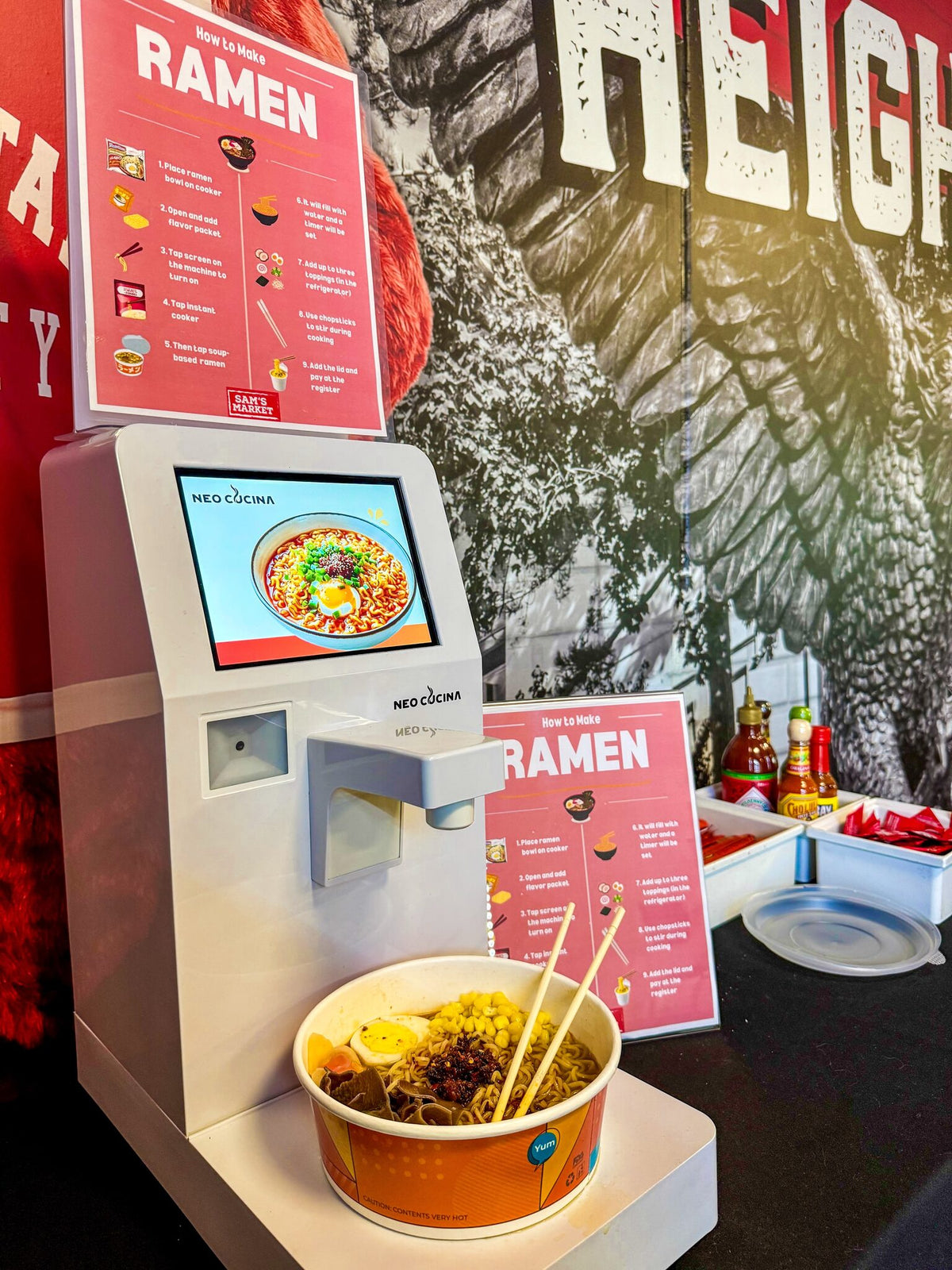 NEO CUCINA Pro cooking a bowl of ramen next to a How to Make Ramen poster at a university market in Montclair, New Jersey