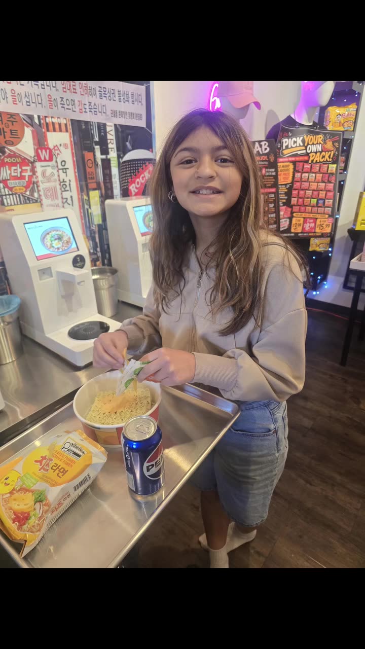 A young customer cooking her own bowl at a NEO CUCINA ramen station in a pickleball club in Saskatoon